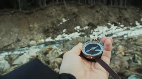First Person Holding Compass Toward Forested Mountain Slope Stock Footage 307092212