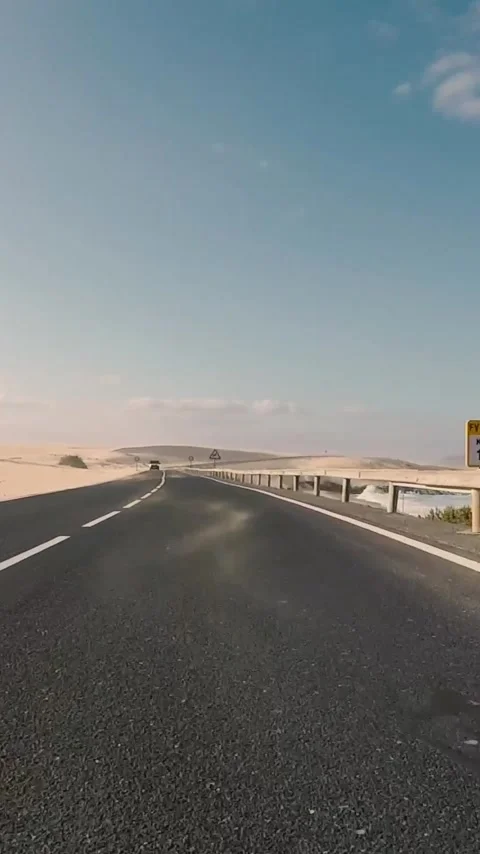 First person perspective driving along an empty asphalt highway through a vast Stock Footage 344847665