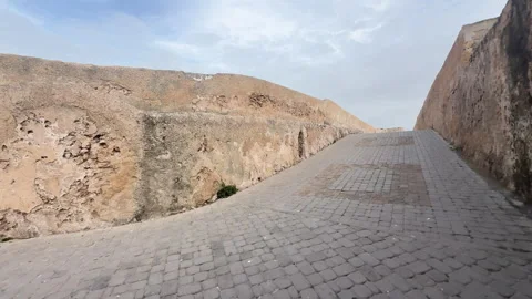 First-person perspective of entering an old city through a gate onto a steep Stock Footage 339565779
