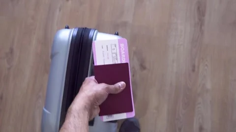 First-person perspective of a hand holding an passport and boarding pass, pul Видео 333302458
