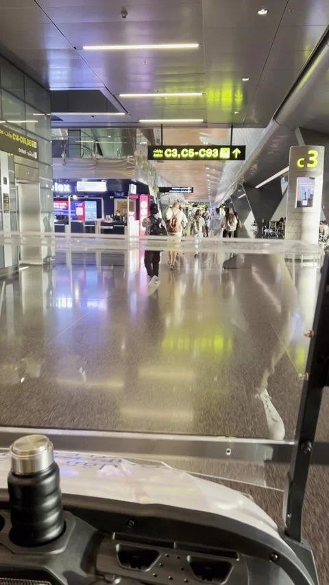 A first-person perspective from inside an airport golf cart, looking down a Stock Footage 337906454