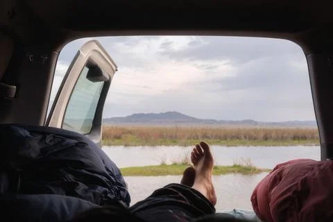 First-person perspective from inside a camper van showing bare feet resting w Foto stock