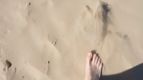 First person perspective of a man walking bare feet on soft sea sand dunes, b Stock Footage 335839355