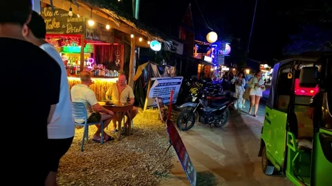 First-person perspective moving slowly past a vibrant tropical bar with people Stock Footage 334162464