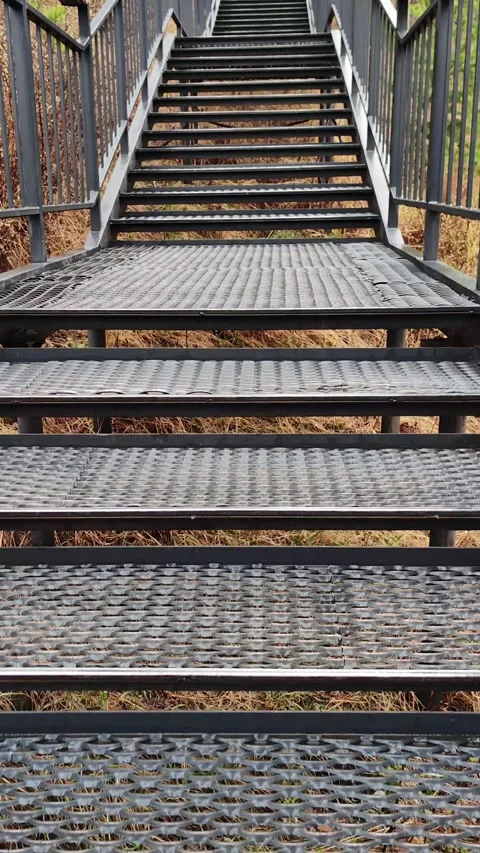 First-person perspective walking up metal staircase outdoors. vertical. Stock Footage 340697321