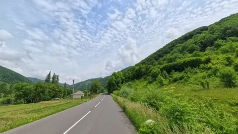 First-person POV driving shot along an empty asphalt road passing through a Vídeo Stock 346181523