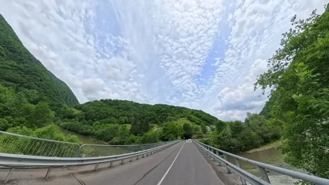 First-person POV driving shot on an asphalt mountain road passing lush green Vídeo Stock 346181582