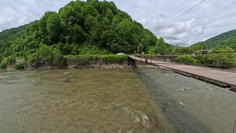 First-person POV perspective looking across a narrow wooden suspension bridge Vídeo Stock 346182340