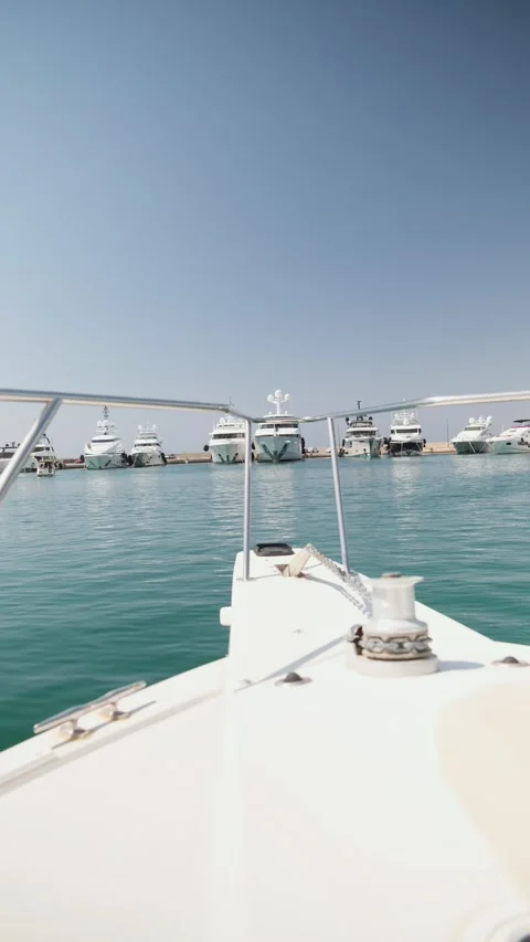 First-person view from a boat navigating towards a marina filled with luxury Stock Footage 337419542