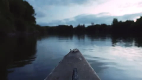 First person view of a boat sailing on a calm river at dusk Stock-Footage 333204893