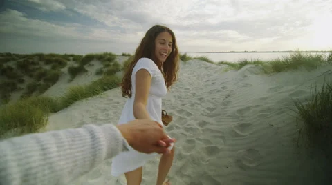 First person view of  couple walking on the beach in slow motion Stock Footage 50060050