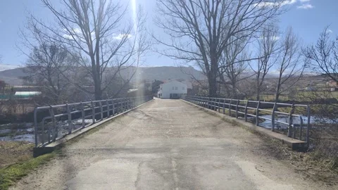 First person view crossing a concrete bridge over a river Stock Footage 340326238