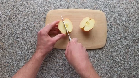First-person view cutting a fresh apple on wooden board Stock Footage 331536483