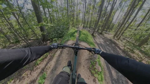 First-person view of a cyclist riding a mountain bike on a singletrack trail Stock Footage 337257687