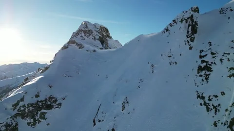 First Person View Drone Descending a Steep Snowy Mountain Peak in Mayrhofen, Stock Footage 334784663