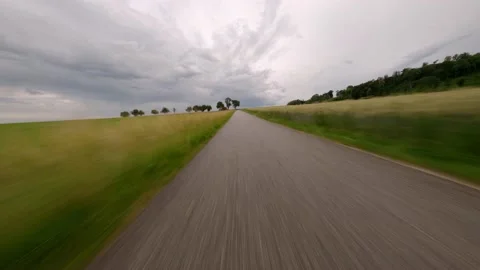 First person view of fast driving low to the ground on a road between Stock Footage