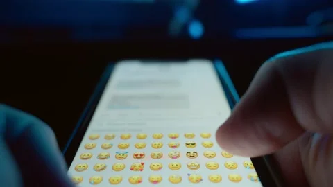 First person view of a guy using a smartphone, selects emoji to send sms. Stock Footage 237437949