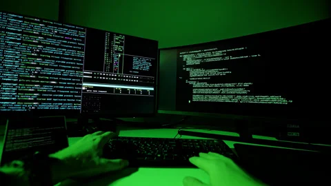 First person view, hacker coding on dual monitors with green cyber glow in room Stock-Footage 317104019