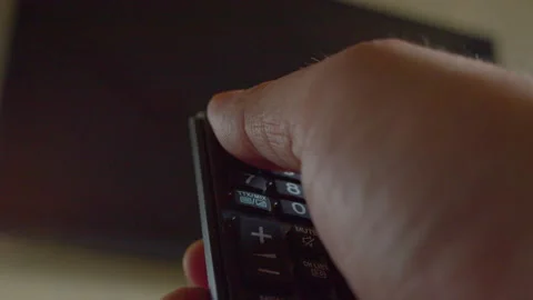 First-person view of a hand using a remote control to turn on a modern TV Stock Footage 335648849