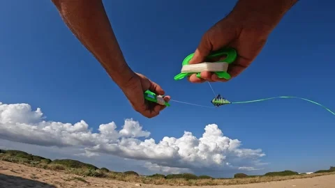 First-person view of hands flying green kite over sandy beach Stock Footage 279866028