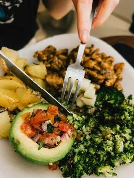 First-person view: Hands skillfully using cutlery while enjoying a healthy Stock Photos