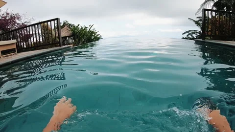 First person view inside infinity pool with rippling turquoise water toward Stock Footage 338437934
