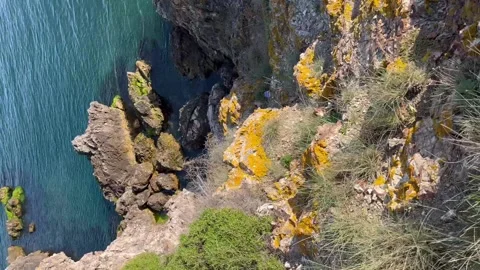 First person view from legs to the cliff sea shore - Vertical stock video Stock Footage 240340651