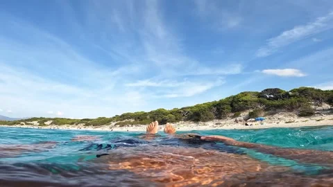 First person view of legs floating in turquoise sea, saleccia Stock Footage 279861669