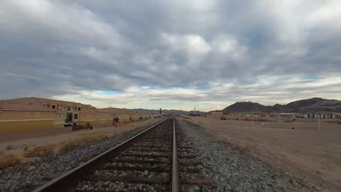 First person view low fast flight over single railway tracks in arid desert Stock Footage 346183898