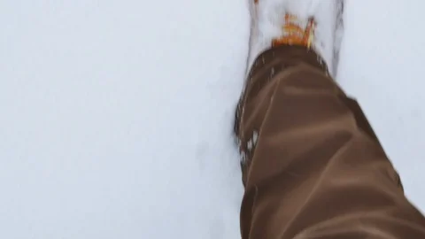 First person view man in big winter boots steps on white snow Vidéo 99158610
