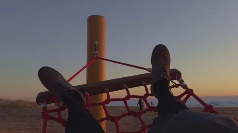 First-person view of a man in black pants and blue sneakers swinging in a Stock Footage 309015029