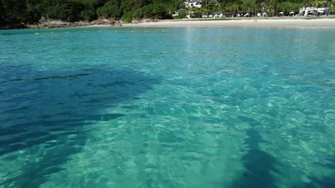 First-person view - a man dangles his legs in transparent sea water Stock Footage 220540762
