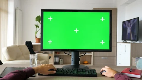 First person view - man hands typing on computer keyboard with big green screen Stock Footage 95682362