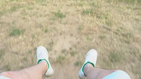 First person view of a man legs riding on a swing, point of view of legs sitting Stock-Footage 244810473