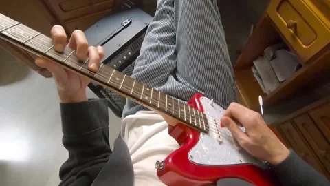 First person view of a man in pajamas playing electric guitar at home. Stock Footage