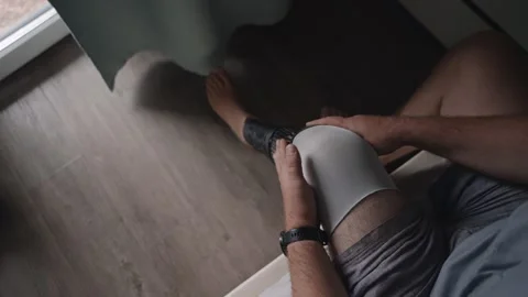 First-Person View of Man Putting on Prosthetic Leg in Bedroom 库存影片 317901192