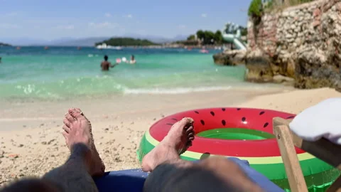 First-person view of a man relaxing on a sunny sandy beach sunbed near crys.. Stock Footage 338808926