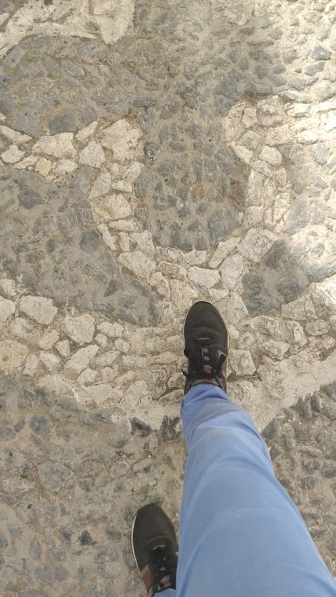 First person view of a man walking on cobblestone street Stock Footage 344692209