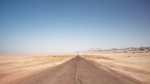 First person view of motion by empty road through the wild desert. Clear blue Stock Footage 253893524