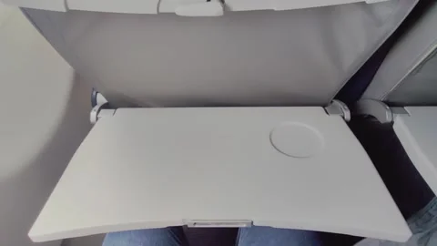 First person view of a passenger opening the tray table on a flight. 스톡 동영상 313241067