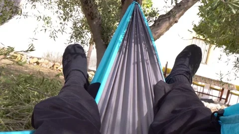 First person view of person lying in a hammock in the countryside on spring d Stock Footage 170884889