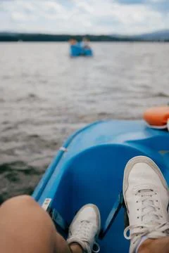 First-person view: point of view of person wearing white sneakers relaxing on Stock Photos