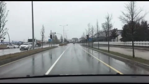A first-person view (POV) from inside a car driving on a wet, rainy multi-lane Stock-Footage 333376654