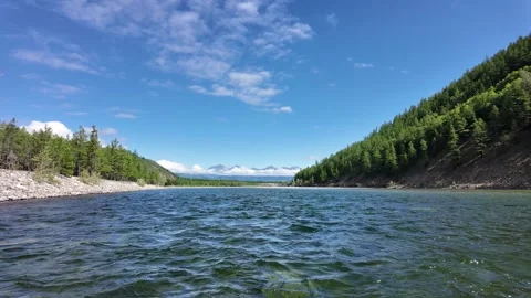 First-person view from a raft drifting through an alpine river  clear water.. Video stock 327854810