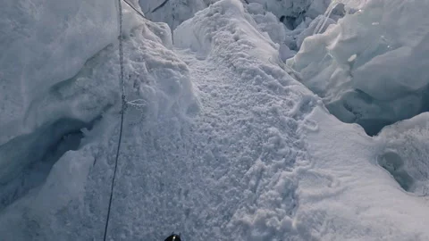 First person view rappelling down an icy glacier crevasse Видео 335495757