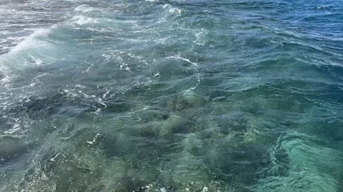First person view of relaxing legs over turquoise sea water Vídeos de archivo 331340033