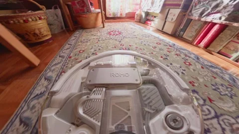 First person view rides on a robot vacuum as it navigates rugs and furniture in Stock Footage 338427166