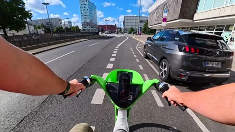 First person view of riding a lime electric scooter on a city street in Berlin Stock Footage 326024898