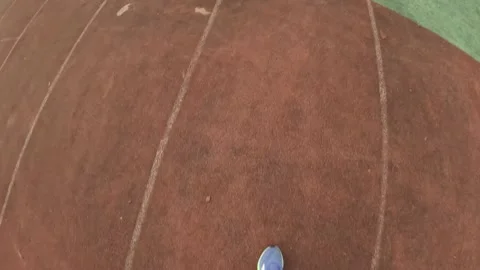 First Person View Running on Worn Stadium Track with Blue White Seating and Stock Footage 321526261