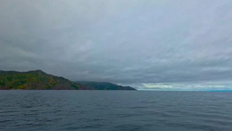 First person view of sailing the ocean along the scenic shores of green mountain Stock Footage 278831659